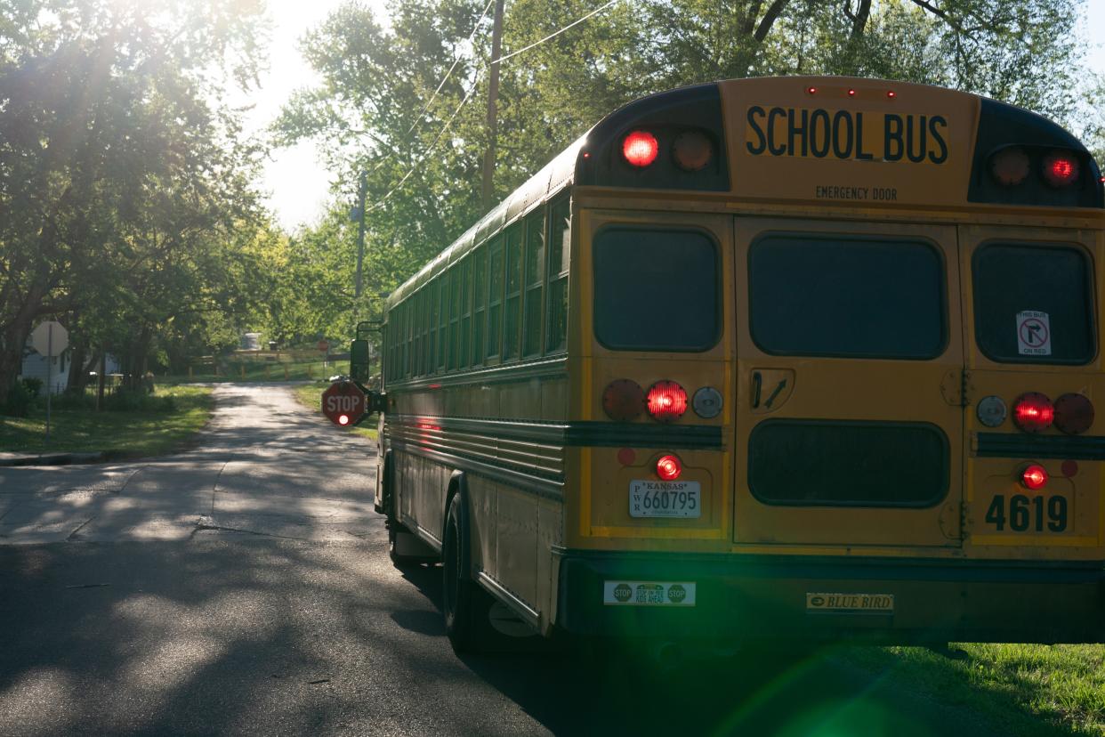 A school bus puts on its flashers and stop sign out during a pickup Wednesday morning in East Topeka.