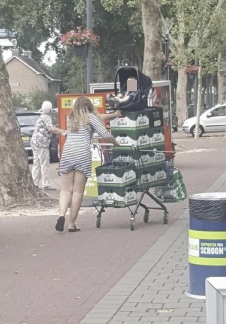 A woman with her baby's car seat on a pile of beer