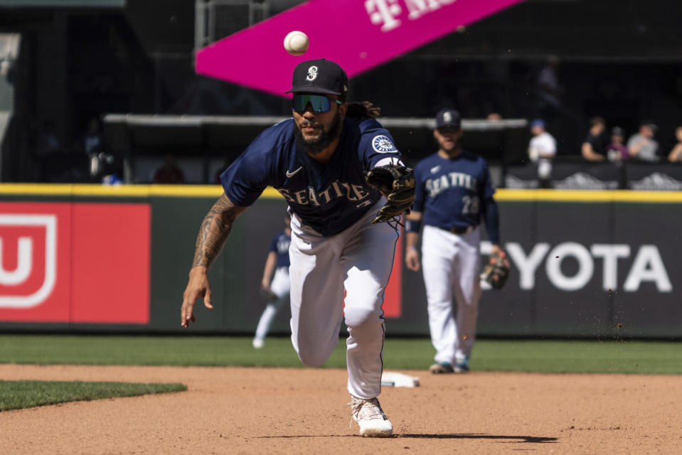 Seattle Mariners shortstop J.P. Crawford tosses a ground ball hit by Cleveland Guardians' Josh Naylor to first base for an out during the seventh inning of a baseball game, Thursday, Aug. 25, 2022, in Seattle. (AP Photo/Stephen Brashear)