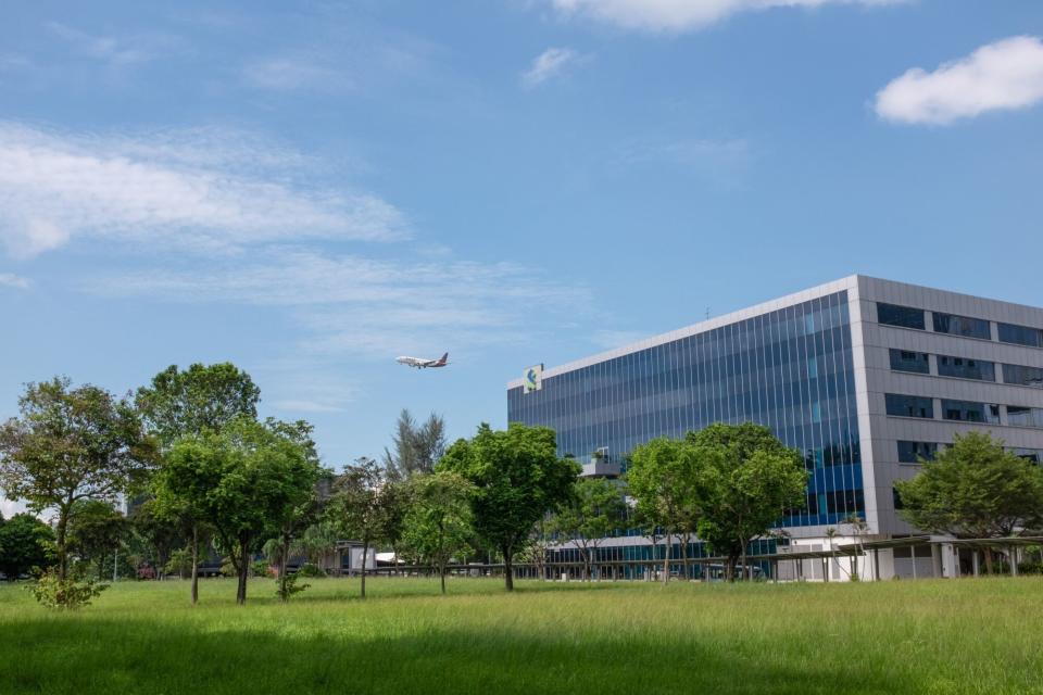 An airplane flies over a Standard Chartered building in Changi Business Park. (Photo: Aparna Nori/Bloomberg(