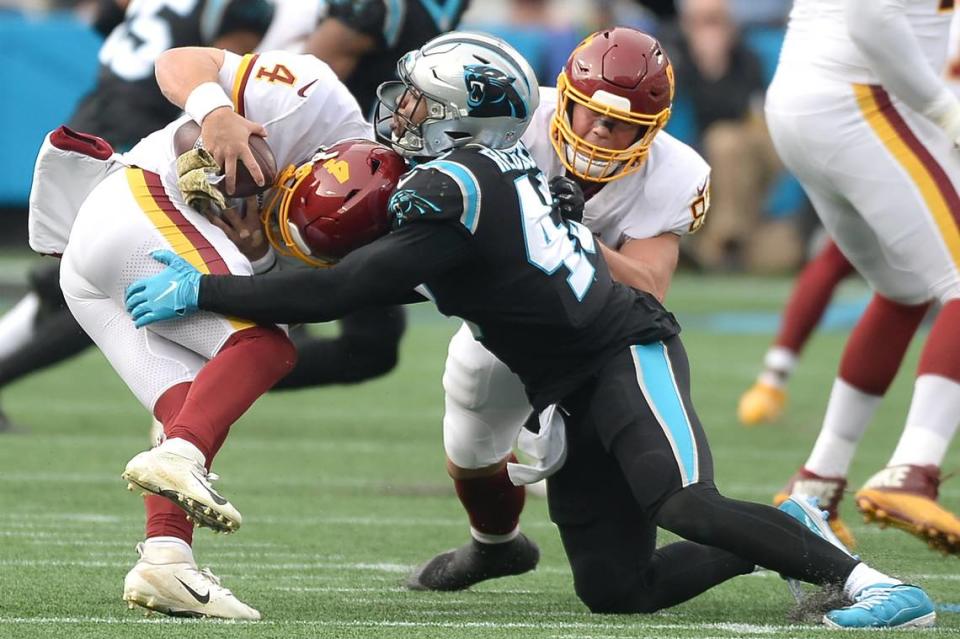 Washington quarterback Taylor Heinicke, left, is sacked by Carolina Panthers linebacker Haason Reddick, right, during second half action at Bank of America Stadium in Charlotte, NC on Sunday, November 21, 2021. Washington defeated the Panthers 27-21.