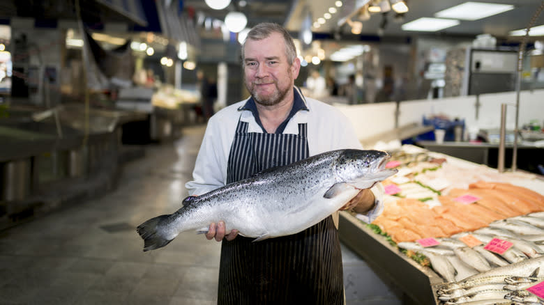 fishmonger holding salmon