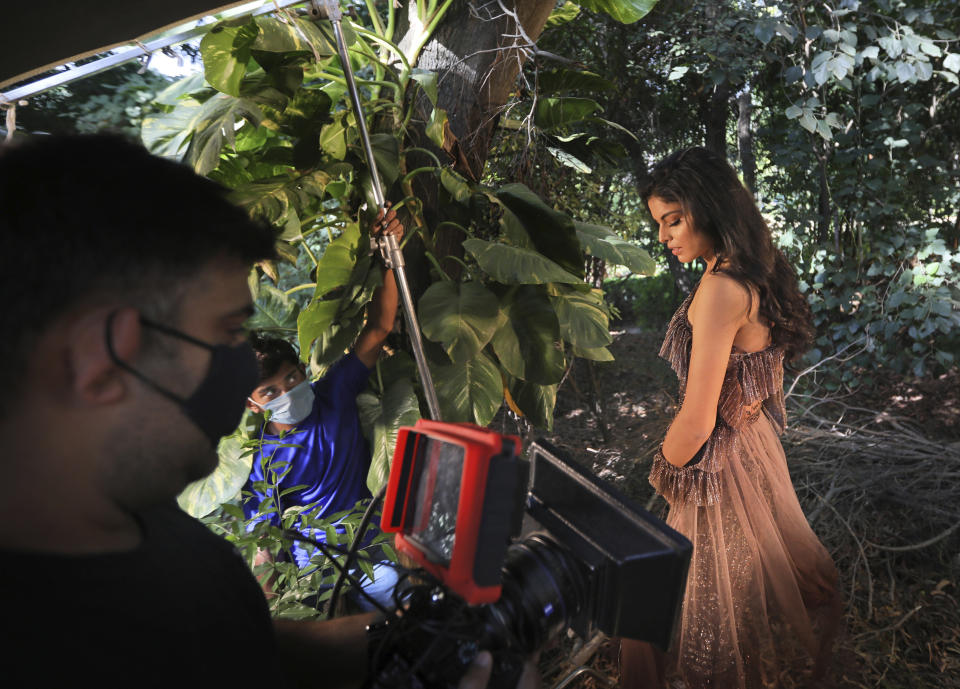 A model poses during a photo shoot for the Lotus Make-up India Fashion Week, at the farmhouse of a designer, in New Delhi, India, Friday, Oct. 2, 2020. Unlike a fashion show, they aren't swaying live on a ramp. They are depending on digital technology to rescue their annual extravaganza from the coronavirus pandemic with ''Phygital edition." India’s first digital fashion week is being held from Oct. 14-18, live streaming the spring-summer collections by more than 40 fashion designers. (AP Photo/Manish Swarup)