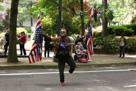 A conservative protestor stands in the middle of the street as conservative and anti-fascist groups hold concurrent rallies in Portland, Oregon, U.S. June 4, 2017. REUTERS/David Ryder