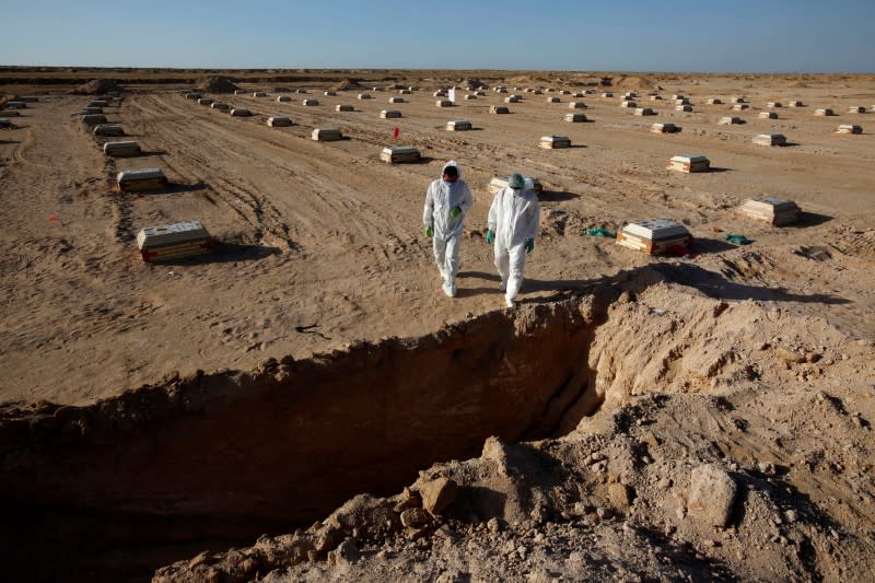 Members of the Popular Mobilization Forces (PMF) bury people who passed away due to coronavirus disease (COVID-19) at the new Wadi Al-Salam cemetery on the outskirts of the holy city of Najaf