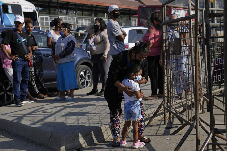 People wait outside Litoral Penitentiary for news of their incarcerated family members after deadly fights inside the jail in Guayaquil, Ecuador, Thursday, July 22, 2021. Rival gangs of inmates fought in two prisons in Ecuador, killing at least 18 people and injuring dozens, authorities said Thursday. (AP Photo/Dolores Ochoa)