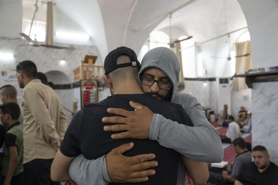 Mohammad Sawafta, front receives condolences from a mourner during the funeral of his father Salah Sawafta, 58 at a mosque, in the West Bank city of Tubas, Friday, Aug. 19, 2022. Israeli forces shot and killed Sawafta during an arrest raid in the occupied West Bank on Friday, according to his brother, who said he was walking home when a bullet struck him in the head as Israeli forces clashed with Palestinian youths. (AP Photo/Nasser Nasser)