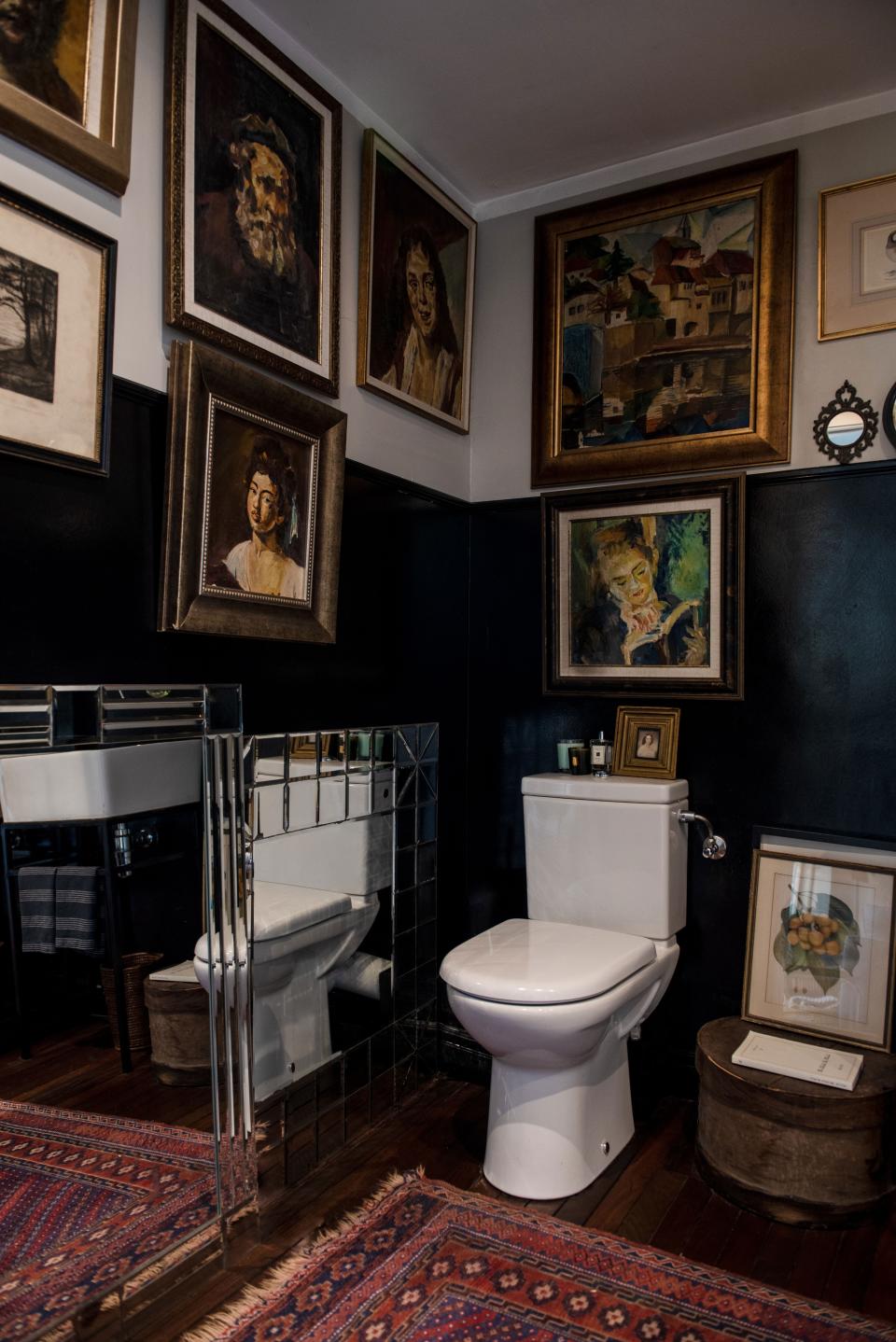 In the guest bathroom on the ground floor, the walls are covered with Broudo’s father’s beloved oil paintings.