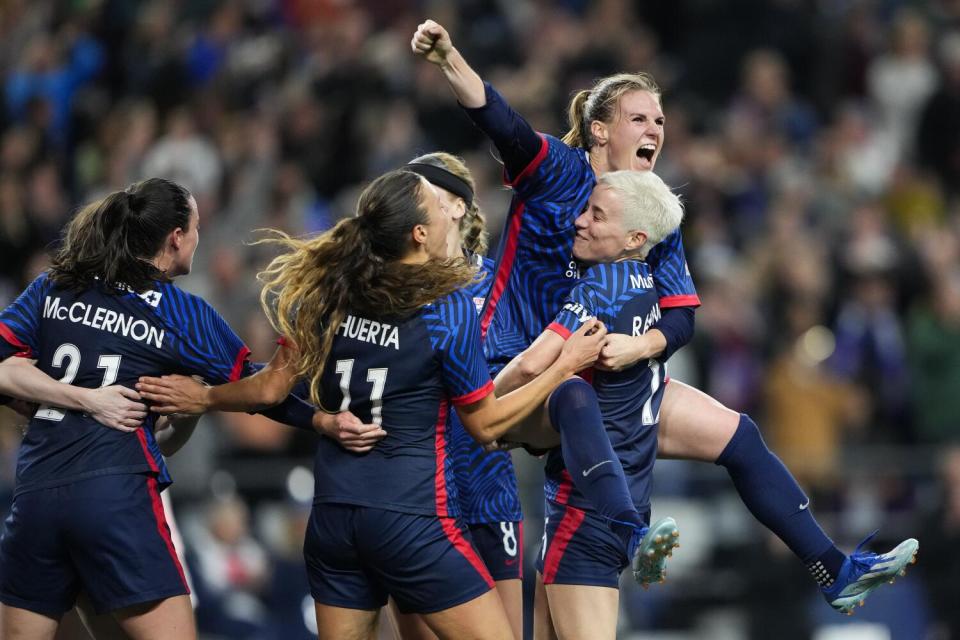 OL Reign forward Veronica Latsko jumps into the arms of Megan Rapinoe while celebrating scoring against Angel City