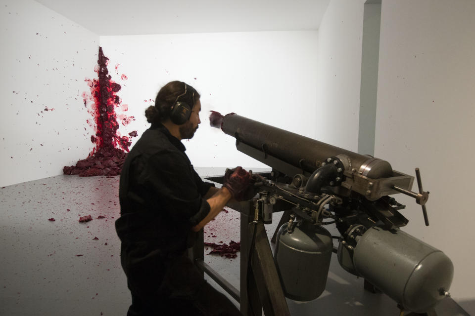 A man performs the art work 'Shooting Into The Corner' by Indian Artist Anish Kapoor in the exhibition 'Kapoor In Berlin' at the Martin-Gropius-Bau museum in Berlin, Friday, May 17, 2013. The exhibition will run from May 18, until Nov. 24, 2013. (Markus Schreiber)