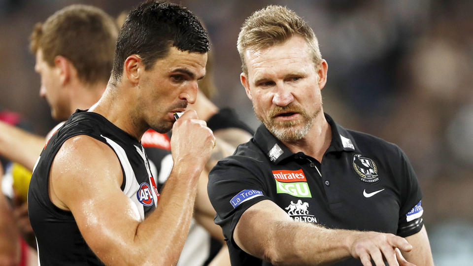 Seen here, Scott Pendlebury chats with Collingwood coach Nathan Buckley.