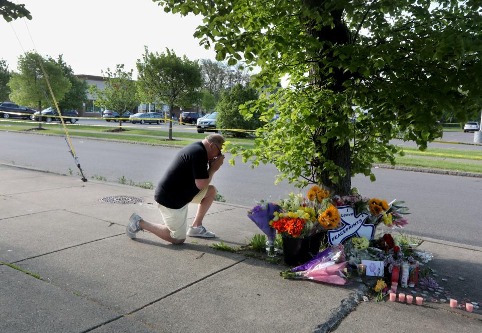 David Lang of Cheektowaga, N.Y., a suburb of Buffalo prays at a memorial across the street from the Tops supermarket where a gunman killed ten people Saturday.