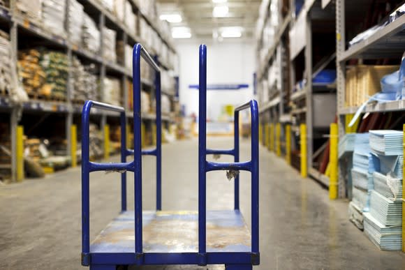 An empty cart sits in a home improvement aisle.