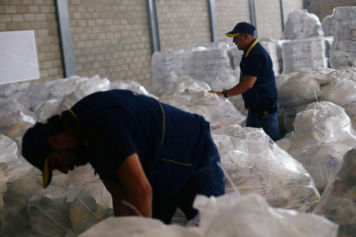 Trabajadores organizan la ayuda humanitaria en un almacén cerca del puente fronterizo Tienditas que une Colombia con Venezuela el 14 de febrero. (REUTERS/Edgard Garrido)