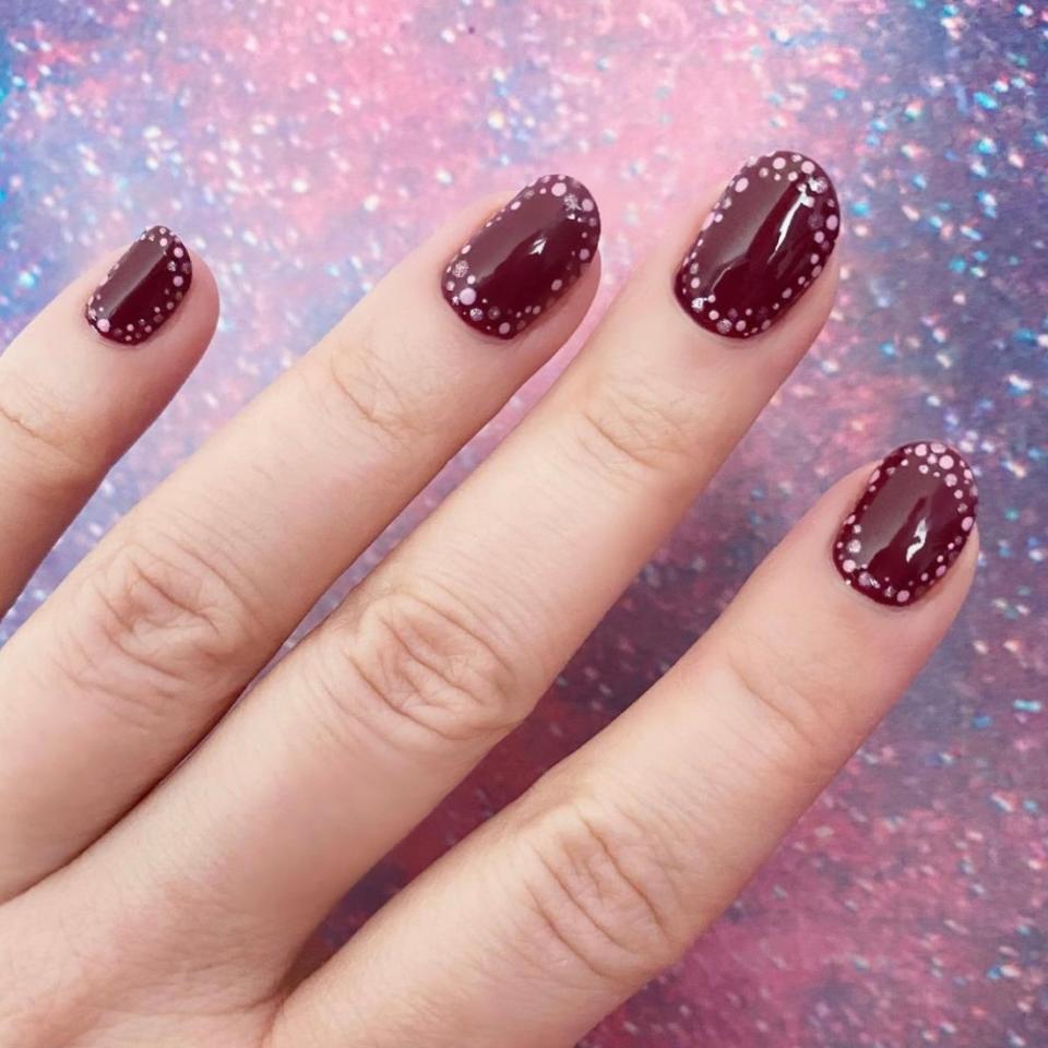 Wine will always be a favorite fall nail color, but if you're in the mood for a little more pizzazz, try this easy <a href="https://www.instagram.com/p/CMKnw8mMeNS/?utm_medium=copy_link" rel="nofollow noopener" target="_blank" data-ylk="slk:DIY nail art;elm:context_link;itc:0;sec:content-canvas" class="link ">DIY nail art</a>. Miss Pop simply dotted around the perimeter of each nail — a dotting tool or toothpick both work — with OPI's light pink <a href="https://shop-links.co/1748994507257477884" rel="nofollow noopener" target="_blank" data-ylk="slk:Another Ramen-tic Evening;elm:context_link;itc:0;sec:content-canvas" class="link ">Another Ramen-tic Evening</a> and shimmery shell <a href="https://shop-links.co/1748994570545978045" rel="nofollow noopener" target="_blank" data-ylk="slk:Throw Me a Kiss;elm:context_link;itc:0;sec:content-canvas" class="link ">Throw Me a Kiss</a>. It completely changes the feel of the sophisticated burgundy shade <a href="https://shop-links.co/1748994646523276958" rel="nofollow noopener" target="_blank" data-ylk="slk:We the Female;elm:context_link;itc:0;sec:content-canvas" class="link ">We the Female</a>.