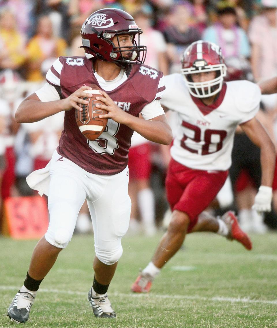 owata High quarterback Treaver Emberson, left, looks to fling the ball while a Dewey pass rusher closes in during varsity football play in 2022.