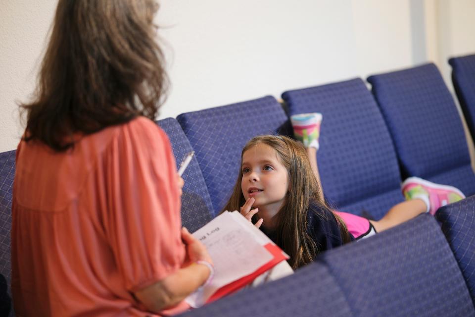 A volunteer works with a child during a Bookworms one-on-one reading session as part of the Project Transformation summer literacy day camp.