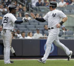 New York Yankees' Adeiny Hechavarria, left, greets Luke Voit who crosses home plate during the first inning of a baseball game against the Baltimore Orioles at Yankee Stadium, Sunday, Sept. 23, 2018, in New York. (AP Photo/Seth Wenig)