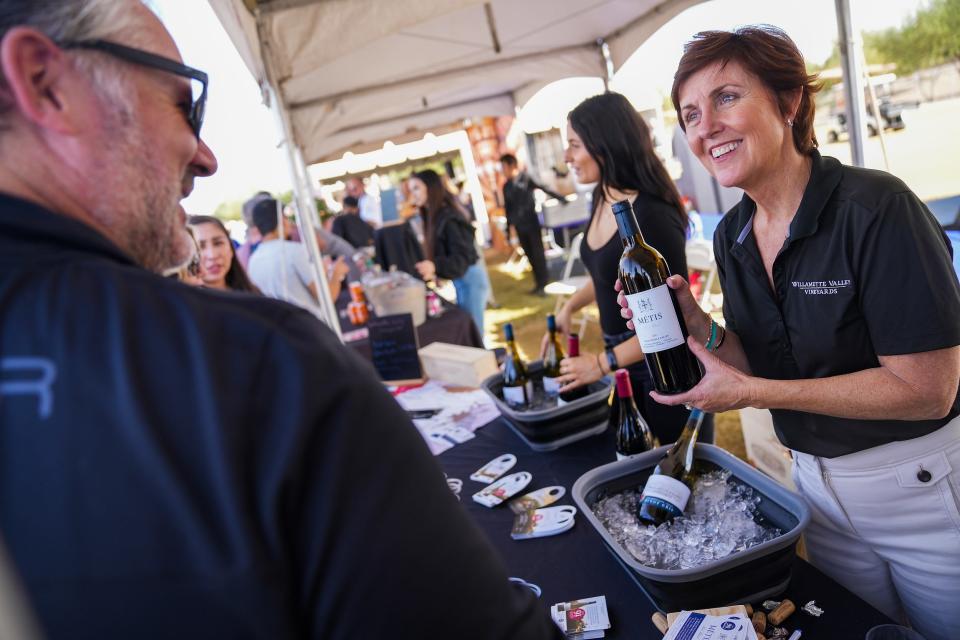Mary Joli, at right, serves Steve Kraus, at left, one of the white wines from Willamette Valley Vineyards during the Phoenix Wine and Food Experience at Salt River Fields at Talking Stick on Saturday, Nov. 5, 2022, in Scottsdale.
