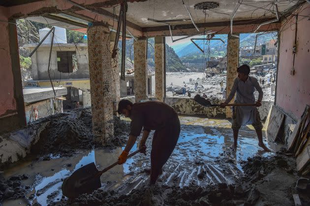 Workers clear sand from a hotel that was damaged by flash floods near the banks of river Swat after heavy rains in Bahrain town of Swat valley in Khyber Pakhtunkhwa province on Aug. 31, 2022. Army helicopters flew sorties over cut-off areas in Pakistan's mountainous north on August 31 and rescue parties fanned out across waterlogged plains in the south as misery mounted for millions trapped by the worst floods in the country's history. (Photo: ABDUL MAJEED/AFP/Getty Images)