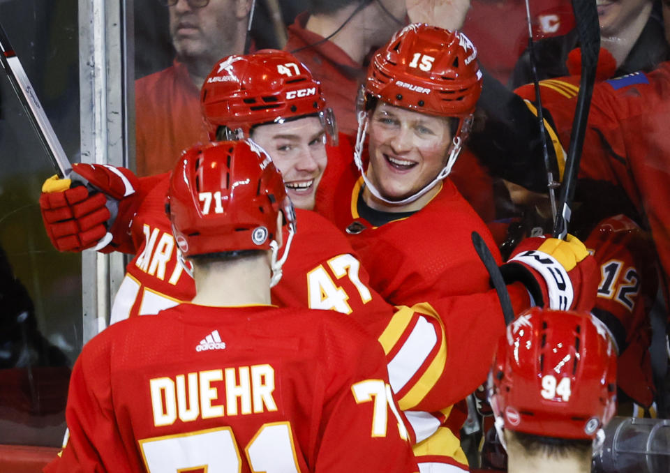 Calgary Flames forward Connor Zary (47) celebrates his goal with teammates forward Dryden Hunt (15) and forward Walker Duehr (71) during the second period of an NHL hockey game against the Arizona Coyotes in Calgary, Alberta, Sunday, April 14, 2024. (Jeff McIntosh/The Canadian Press via AP)