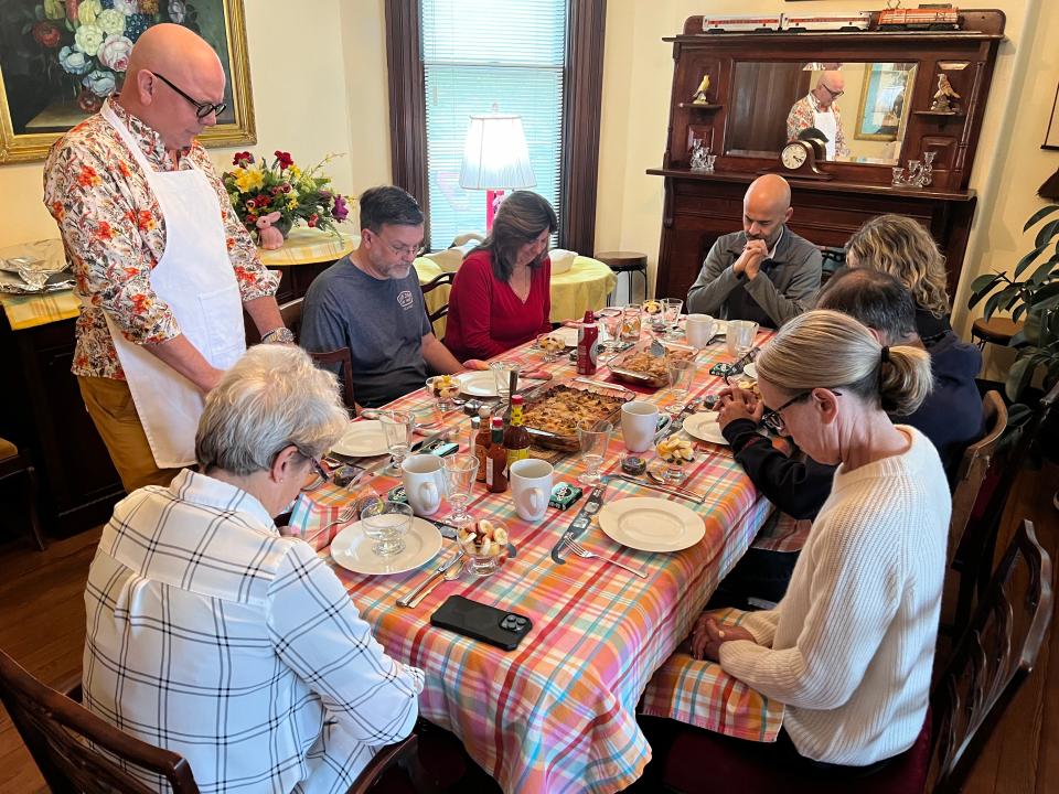 L&N Bed & Breakfast host Greg Gibson, standing, asks the blessing as seven of his 10 overnight guests gather for breakfast on Monday morning. The guests came from Denver, the Atlanta area, Ocala, Florida and Murray, Kentucky.