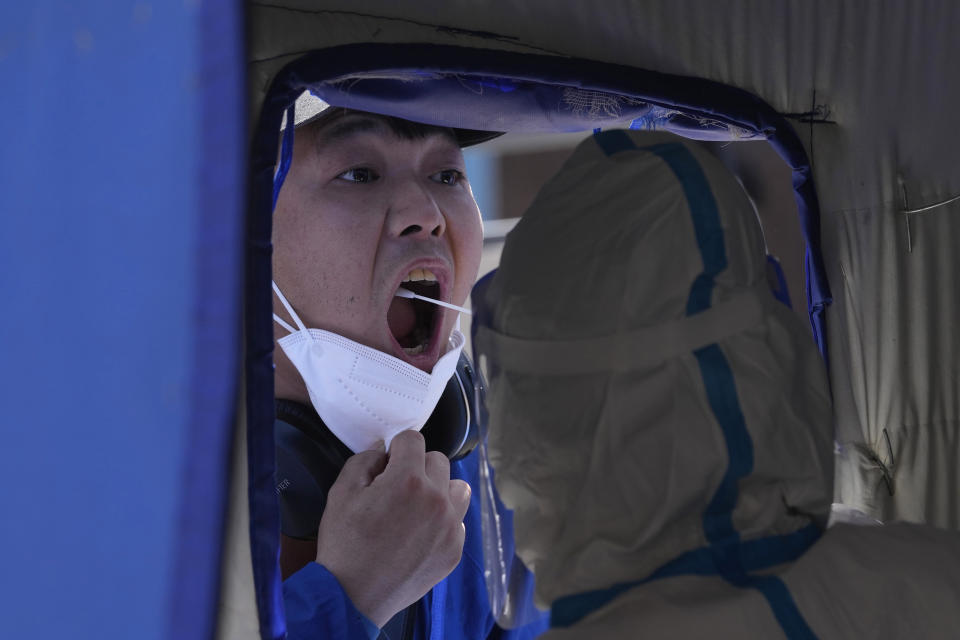 A resident gets swabbed during mass COVID test, Friday, May 27, 2022, in Beijing. (AP Photo/Ng Han Guan)