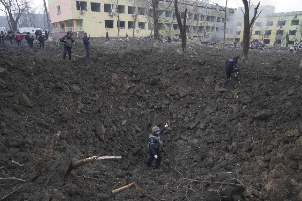 FILE - Ukrainian soldiers and emergency employees work outside a maternity hospital damaged by shelling in Mariupol, Ukraine, Wednesday, March 9, 2022. A Russian attack severely damaged the hospital in the besieged port city of Mariupol, Ukrainian officials said. (AP Photo/Evgeniy Maloletka, File)