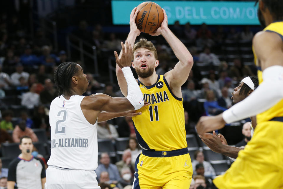 Indiana Pacers center Domantas Sabonis (11) takes the ball to the basket against Oklahoma City Thunder guard Shai Gilgeous-Alexander (2) in the first half of an NBA basketball game Friday, Jan. 28, 2022, in Oklahoma City. (AP Photo/Nate Billings)