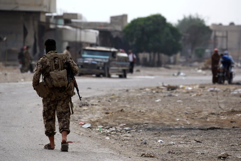 Turkey-backed Syrian rebel fighter walks near Ras al Ain Town