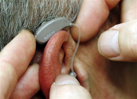 An employee of GN, the world's fourth largest maker of hearing aids, demonstrates the use of ReSound LiNX in Vienna November 22, 2013. REUTERS/Heinz-Peter Bader