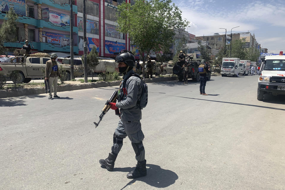 An Afghan police officer arrives at the site where gunmen attacked, in Kabul, Afghanistan, Tuesday, May 12, 2020. Gunmen stormed a hospital in the western part of the Afghan capital on Tuesday, setting off a gun battle with the police, officials said. (AP Photo/Rahmat Gul)