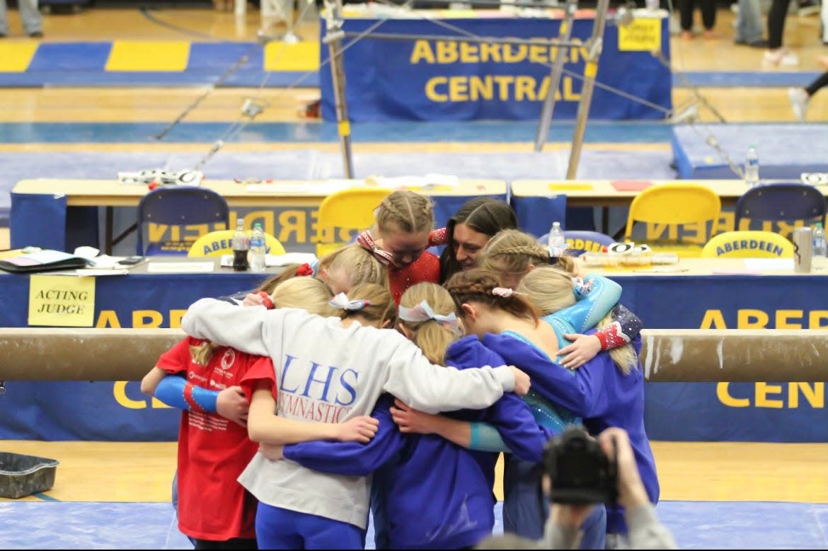 The Lincoln High School gymnastics team huddles together.