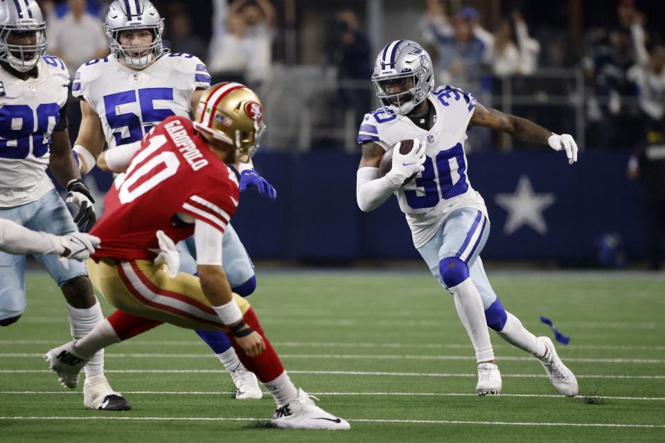 San Francisco 49ers quarterback Jimmy Garoppolo (10) attempts to defend against Dallas Cowboys cornerback Anthony Brown (30) who intercepted a pass thrown by Garoppolo in the second half of an NFL wild-card playoff football game in Arlington, Texas, Sunday, Jan. 16, 2022. (AP Photo/Ron Jenkins)