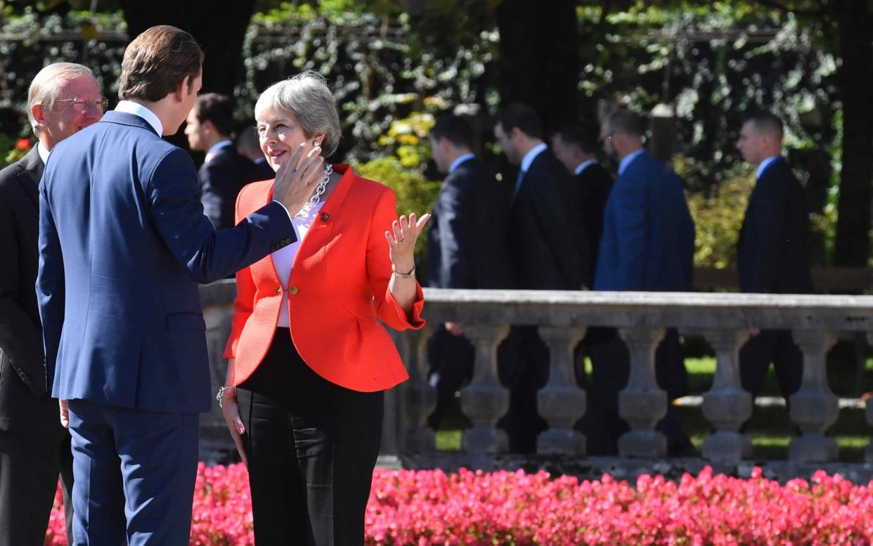 Austrian Chancellor Sebastian Kurz talks to Theresa May when arriving for the family photo at the informal EU summit in Salzburg - AP