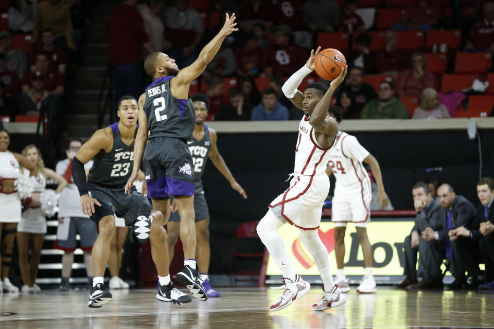 Oklahoma's De'Vion Harmon throws the ball away from TCU's Edric Dennis Jr. during the first half of an NCAA college basketball game in Norman, Okla., Saturday, Jan. 18, 2020. (AP Photo/Garett Fisbeck)