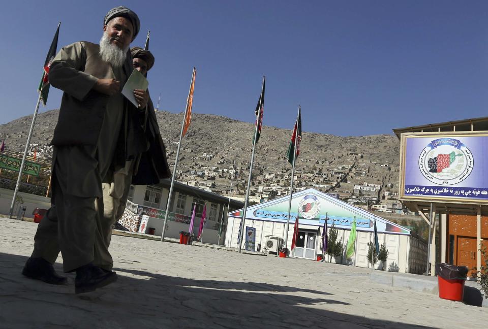 Members of a traditional Afghan grand assembly convened to debate matters of national importance known as a "Loya Jirga" walk outside a giant tent in Kabul November 17, 2013. Thousands of Afghan tribal and political leaders will gather in the Afghan capital this week to decide whether to allow U.S. troops to stay after the 2014 drawdown of foreign forces. Picture taken November 17, 2013. REUTERS/Omar Sobhani (AFGHANISTAN - Tags: POLITICS MILITARY)