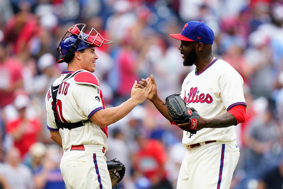 Philadelphia Phillies pitcher Enyel De Los Santos, right, and catcher J.T. Realmuto celebrate after the Phillies won a baseball game against the New York Yankees, Sunday, June 13, 2021, in Philadelphia. (AP Photo/Matt Slocum)