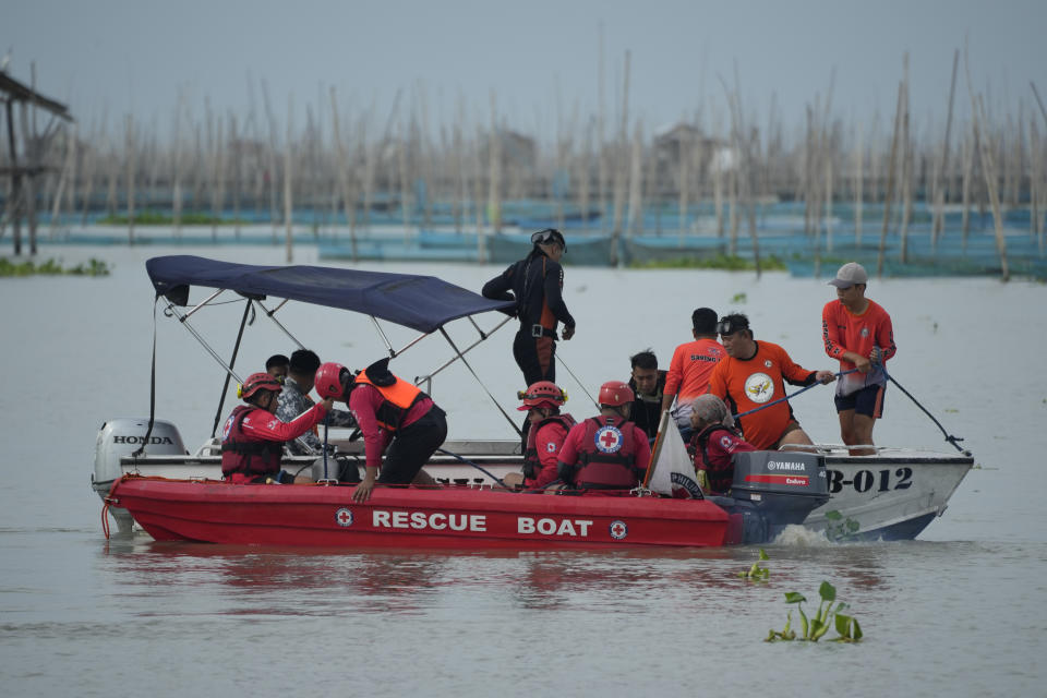 Rescuers search for missing passengers from a boat that capsized in Binangonan, Rizal province, Philippines on Friday, July 28, 2023. A small Philippine ferry turned upside down when passengers suddenly crowded to one side in panic as fierce winds pummeled the wooden vessel, leaving multiple people dead while others were rescued, officials said Friday. (AP Photo/Aaron Favila)