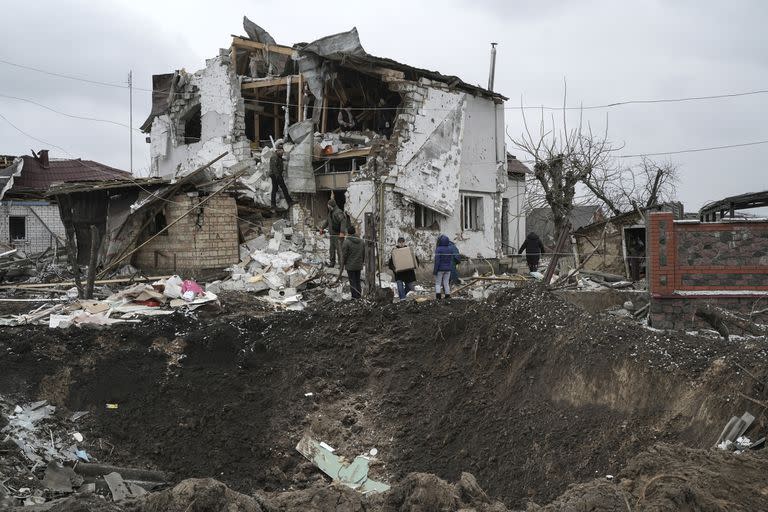 El cráter de una explosión se ve junto a una casa destruida después de un ataque con cohetes rusos en Hlevakha, región de Kyiv, Ucrania, el jueves 26 de enero de 2023