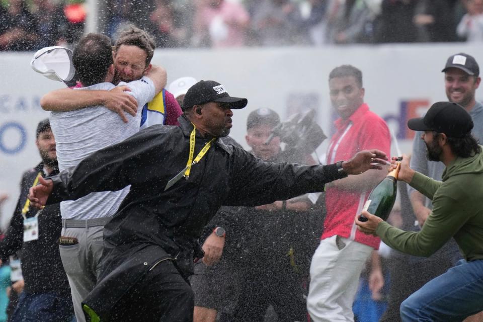 A security moves in to tackle champagne-wielding Adam Hadwin  (AP)