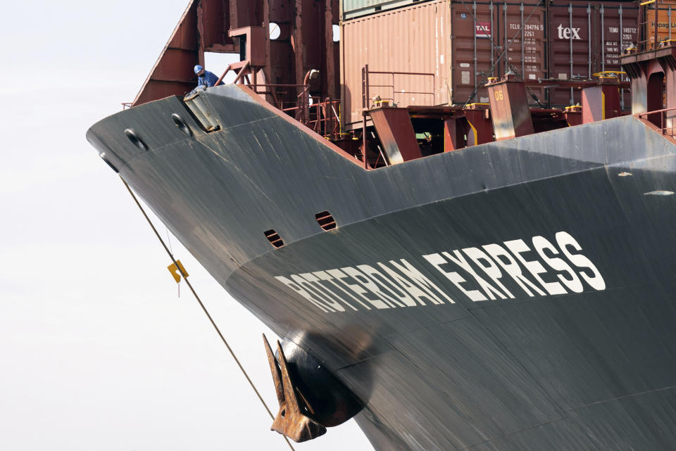 A worker looks over the edge of the Rotterdam Express at the Port of Oakland, Wednesday, Oct. 6, 2021 in Oakland, Calif. The Rotterdam Express, a massive cargo ship made a series of unusual movements while anchored in the closest spot to a Southern California oil pipeline that ruptured and sent crude washing up on beaches, according to data collected by a marine navigation service. (AP Photo/Josh Edelson)