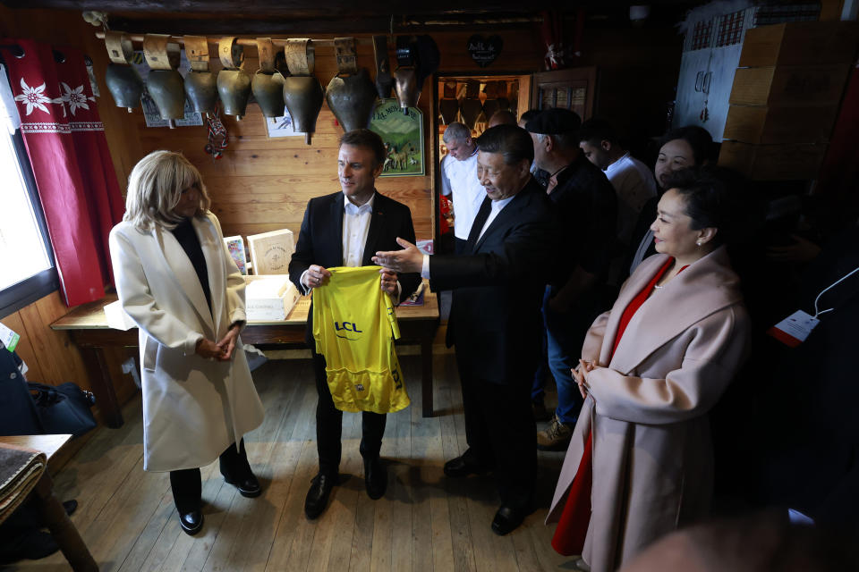 Chinese President Xi Jinping, second right, and his wife Peng Liyuan, right, French President Emmanuel Macron, holding a Tour de Francecycling race jersey and his wife Brigitte Macron, left, discuss in a restaurant, Tuesday, May 7, 2024 at the Tourmalet pass, in the Pyrenees mountains. French president is hosting China's leader at a remote mountain pass in the Pyrenees for private meetings, after a high-stakes state visit in Paris dominated by trade disputes and Russia's war in Ukraine. French President Emmanuel Macron made a point of inviting Chinese President Xi Jinping to the Tourmalet Pass near the Spanish border, where Macron spent time as a child visiting his grandmother. (AP Photo/Aurelien Morissard, Pool)