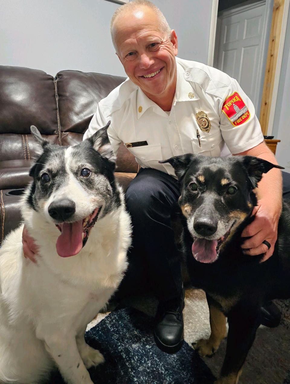 Topeka Fire Chief Randy Phillips posed with his dogs, Patches, left, and Sox, right.