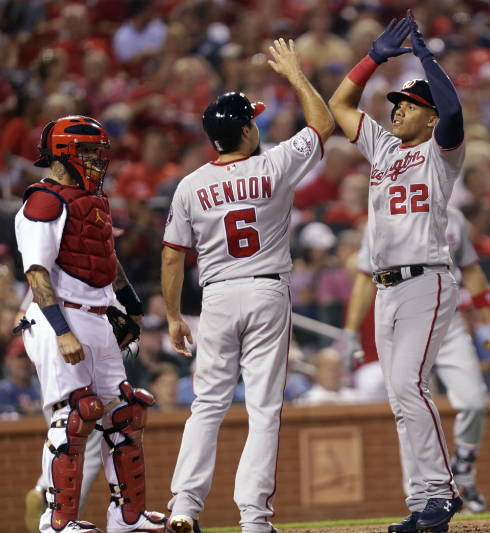 Washington Nationals' Juan Soto (22) celebrates with teammate Anthony Rendon (6) after hitting a two-run home run, as St. Louis Cardinals catcher Yadier Molina looks on, in the seventh inning of a baseball game, Monday, Aug. 13, 2018, in St. Louis. (AP Photo/Tom Gannam)