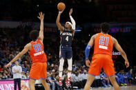 New Orleans Pelicans guard Devonte' Graham (4) shoots against Oklahoma City Thunder forward Jeremiah Robinson-Earl (50) and guard Aaron Wiggins (21) during the second half of an NBA basketball game, Sunday, Dec. 26, 2021, in Oklahoma City. (AP Photo/Garett Fisbeck)