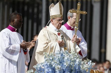 Pope Francis walks with his pastoral cross as he leads the Easter mass in Saint Peter's Square at the Vatican April 20, 2014. REUTERS/Tony Gentile