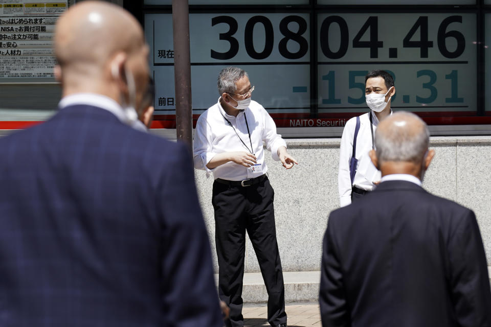 People stand in front of an electronic stock board showing Japan's Nikkei 225 index at a securities firm Wednesday, May 24, 2023, in Tokyo. Asian stock markets slid Wednesday as the U.S. government crept closer to a potentially disruptive default on its debt. (AP Photo/Eugene Hoshiko)