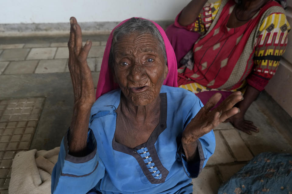 A woman gestures as she with other families take shelter in a school after fleeing from their villages of costal areas due to Cyclone Biparjoy approaching, in Gharo near Thatta, a Pakistan's southern district in the Sindh province, Wednesday, June 14, 2023. In Pakistan, despite strong winds and rain, authorities said people from vulnerable areas have been moved to safer places in southern Pakistan's districts. With Cyclone Biparjoy expected to make landfall Thursday evening, coastal regions of India and Pakistan are on high alert. (AP Photo/Fareed Khan)