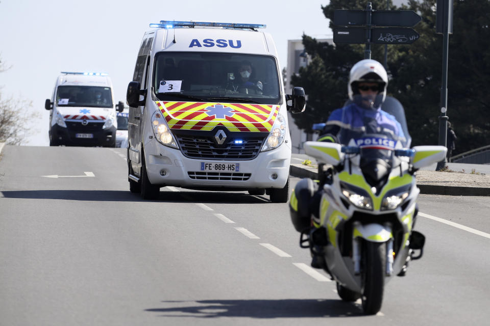 Escorted ambulances drive from the train station to an hospital Wednesday April 1, 2020 in Rennes, western France. France is evacuating 36 patients infected with the coronavirus from the Paris region onboard two medicalized high-speed TGV trains. The patients, all treated in intensive care units (ICU), are being transferred to several hospitals in Britany, as western France is less impacted by the epidemic. The new coronavirus causes mild or moderate symptoms for most people, but for some, especially older adults and people with existing health problems, it can cause more severe illness or death. (AP Photo/David Vincent)